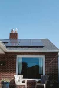 Solar panels on a brick house roof with clear spring sky