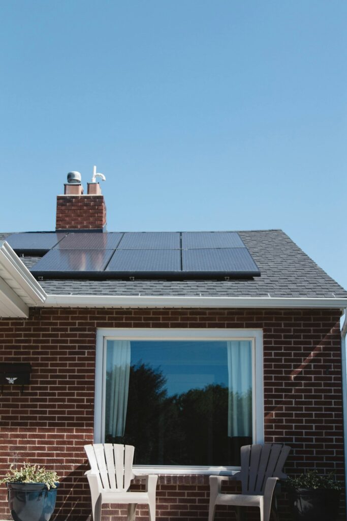 Solar panels on a brick house roof with clear spring sky