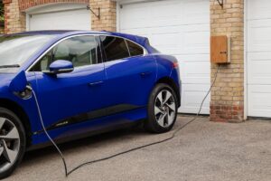 Electric car plugged into home charging station