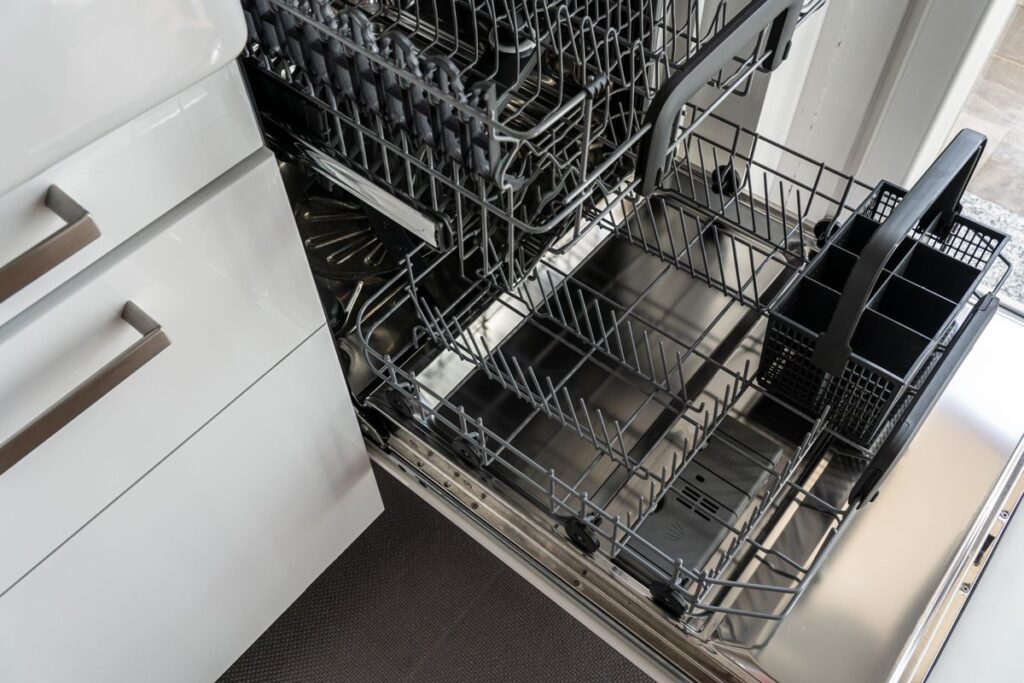 Open stainless steel dishwasher in a modern kitchen