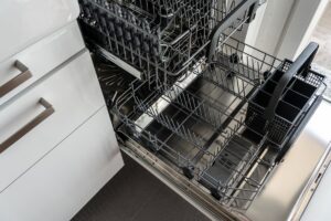 Open stainless steel dishwasher in a modern kitchen