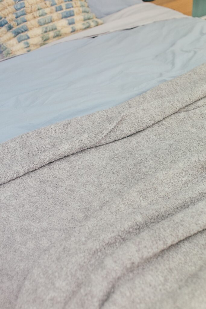 Cosy warm blanket on a made bed in a bedroom